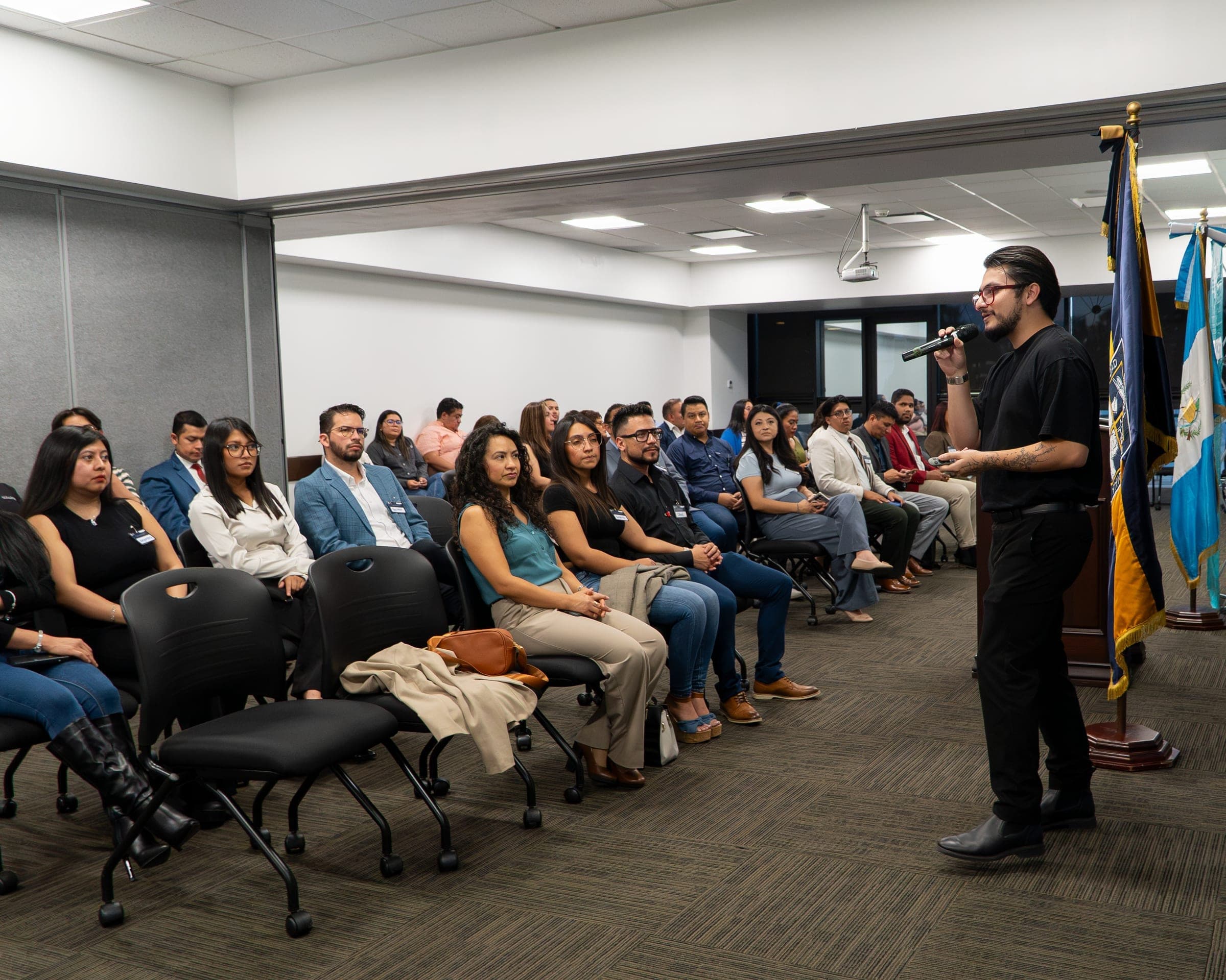 Marcello Sisniega presentando ante una sala amplia de asistentes en un evento corporativo
