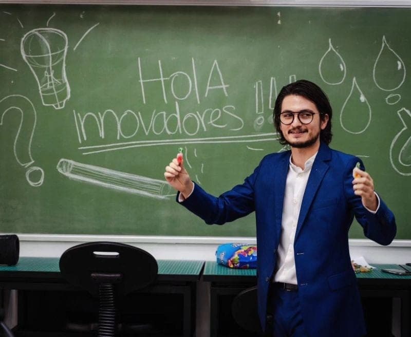 Marcello Sisniega frente a un pizarrón con la frase 'Hola innovadores' durante un taller universitario