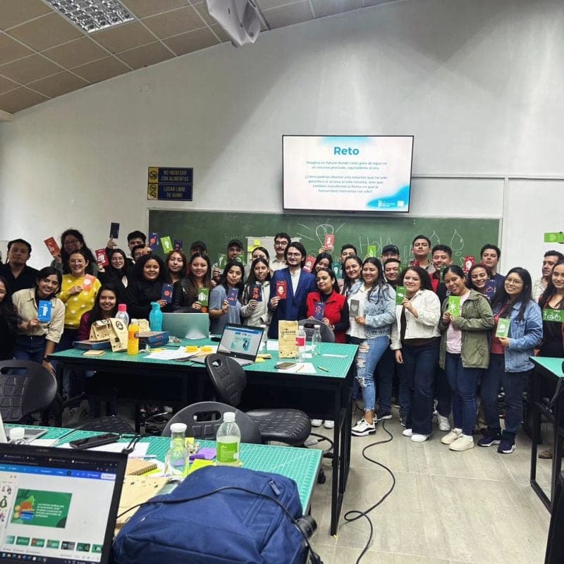Marcello Sisniega en foto grupal con estudiantes al final de un taller de innovación en un salón universitario
